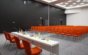 下塔吉尔Demidov Plaza的一间会议室,配有白色的桌子和橙色的椅子