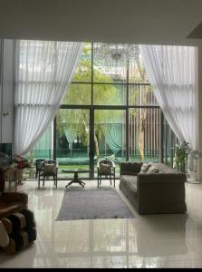 塞贝维New - Villa with Private Pool & Jacuzzi for 20 ppl in Puchong and Cyberjaya的带沙发和大窗户的客厅