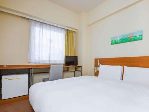 盐尻市Comfort Inn Shiojiri Kita Inter的酒店客房配有一张床和一张带电脑的书桌