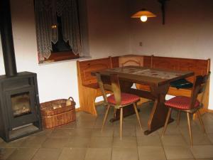 Waldthurn拜姆勒度假乡村民宿的一间带桌子和燃木炉的用餐室