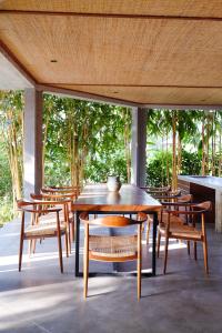 坎古Planta Boutique Resort的天井上的木桌和椅子