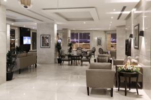 阿可贺巴Aswar Al Olaya Hotel Suites的一个带椅子和桌子的大堂以及一间用餐室