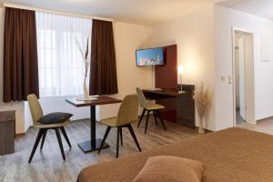 肯普滕笔城旅馆的酒店客房带一张床、一张桌子和椅子
