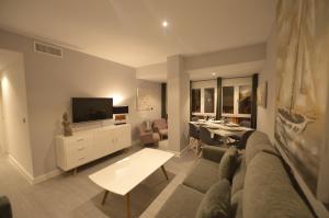 加的斯维多利亚公寓的带沙发、电视和桌子的客厅