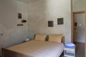 阿拉Agriturismo Maso Rocca的一间卧室配有白色床单