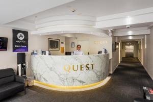 基督城Quest Cathedral Junction Serviced Apartments的站在大堂柜台后面的人