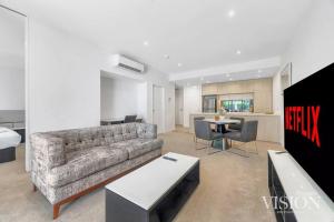 悉尼Modern 2 Bedroom Apartment next to North Ryde Metro的客厅配有沙发和桌子