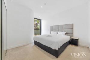 悉尼Modern 2 Bedroom Apartment next to North Ryde Metro的一间卧室设有一张大床和一个窗户。