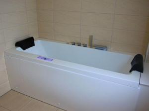 格洛韦Haus Annette的瓷砖浴室设有白色浴缸。