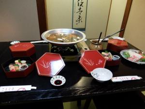 长野叶木纳卡尼日式旅馆的餐桌,炉子上放着一碗食物