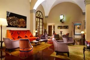 佛罗伦萨Hotel L'Orologio - WTB Hotels的客厅配有橙色沙发和椅子