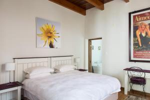 弗朗斯胡克万维克街22号观光旅馆的卧室配有一张白色的大床和一张照片