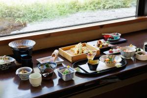 京都Kadensho, Arashiyama Onsen, Kyoto - Kyoritsu Resort的一张桌子,上面放着几盘食物,还有一个窗口