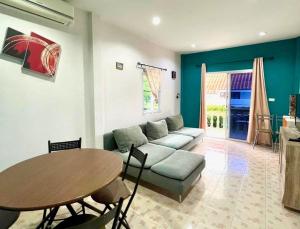 Ban Suan2 bedroom bungalow Nai Harn 4 Resort的客厅配有沙发和桌子