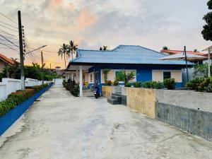 Ban Suan2 bedroom bungalow Nai Harn 4 Resort的蓝色屋顶和街道的房子