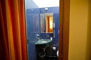 罗马利拉酒店的蓝色瓷砖浴室设有水槽和镜子