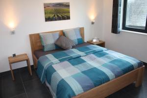 Erpe-Mere卡佩霍夫酒店的一间卧室配有一张带蓝色和白色棉被的床