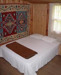 奥林波斯柏拉姆斯树之家酒店的一间卧室配有一张带白色床单的床和一扇窗户。