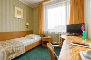 奥普尔节日酒店的酒店客房配有一张床和一张书桌及一台电视