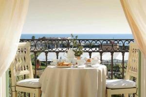 埃尔科拉诺Casa Raiola Ercolano Luxury Rooms & Spa的阳台上的一张桌子和白色的桌布