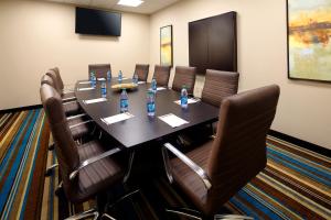 布里奇波特Hawthorn Suites by Wyndham Bridgeport的一间会议室,配有长桌和皮椅