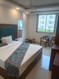 新德里Hotel Blue Krone Near Delhi Airport的一间卧室配有一张床、两把椅子和一个窗户