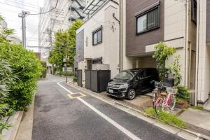 东京Ikebukuro house with 3BR Shinjuku 5min的停在大楼旁的街道边的汽车