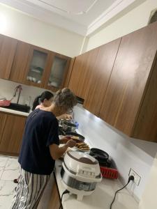 枚州县Mai chau Horizon Homestay的站在厨房准备食物的妇女