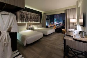 吉隆坡吉隆坡杂志酒店的酒店客房,设有两张床,享有城市天际线。
