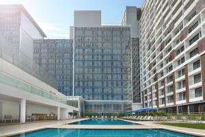 马六甲Noble Resort Hotel Melaka的两个高楼中间的一个游泳池