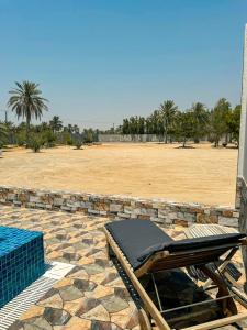 Al RahbaLuxury Farmhouse Near Yas Island With Swimming Pool, BBQ Area & Majlis的田野旁天井上的躺椅