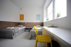 华沙Sport Hostel Chodakowska Warszawa的一间卧室配有一张床和一张黄色椅子