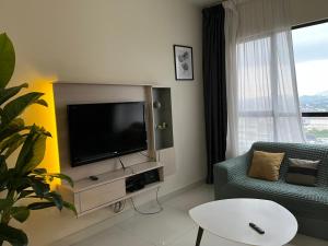 加影Casa RV Homestay MKH Boulevard Kajang的客厅配有电视、沙发和桌子