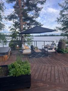 Jyväskylän MaalaiskuntaLarge house with private beach near Jyväskylä的一个带桌椅和遮阳伞的甲板