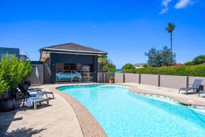 蚬壳港Spectacular Ocean Front home With Pool的一个带椅子的游泳池以及一座房子