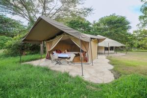 育空河Dolly Farm & River Camp, Luxury Tents的田野上带桌椅的帐篷