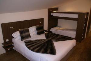 卡尼略Hotel L’Ermita B&B的一间卧室配有两张双层床和毛巾