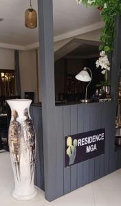 OuidahRESIDENCE MGA HOTEL的商店柜台旁的白色花瓶