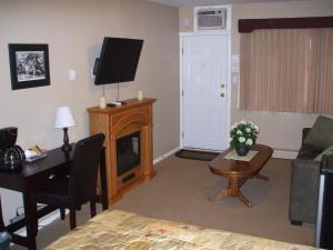 克兰布鲁克Travellers Motel的客厅配有床、书桌和电视