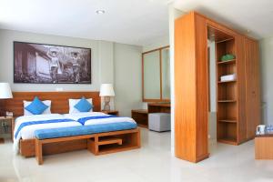 乌布乌布水仙度假及别墅酒店的一间卧室配有一张带蓝色枕头的大床