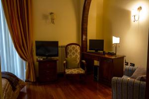 ForchiaCamere al Borgo的客房设有书桌、电视和椅子