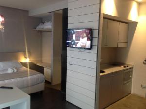 贝拉里亚-伊贾马里纳贝尔套房酒店的小房间设有床铺和墙上的电视