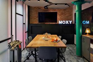 华沙Moxy Warsaw Praga的一间会议室,配有木桌和电视