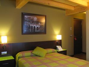 里瓦德奥罗尔酒店的卧室配有一张床,墙上挂着一幅画