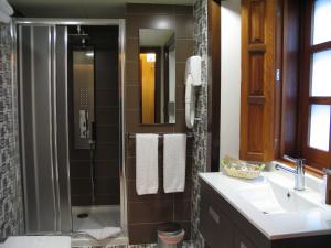 里瓦德奥罗尔酒店的带淋浴、盥洗盆和镜子的浴室