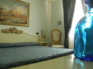 奎托·迪·特雷维索科尔蒂纳莫布勒住宿加早餐旅馆的一间卧室配有一张床,一张蓝色的花瓶放在桌子上