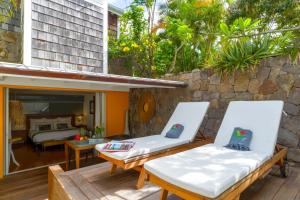 Saint BarthelemyCharming bungalow in Saint Barthelemy with shared pool的一个带两把椅子的庭院和一间卧室