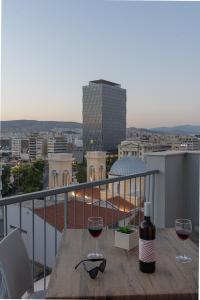 比雷埃夫斯Piraeus City Hotel的阳台上的桌子和两杯葡萄酒