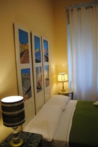 那不勒斯安吉拉之家酒店的卧室配有一张床,墙上挂有图片