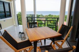 BoscobelOcean View Villa, Infinity Pool, AC, Staff, Wi-Fi的阳台上的木桌和椅子